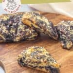 Triangular black raspberry scones with a sugar topping are arranged on a wooden board. The text above showcases these delicious black raspberry scones.