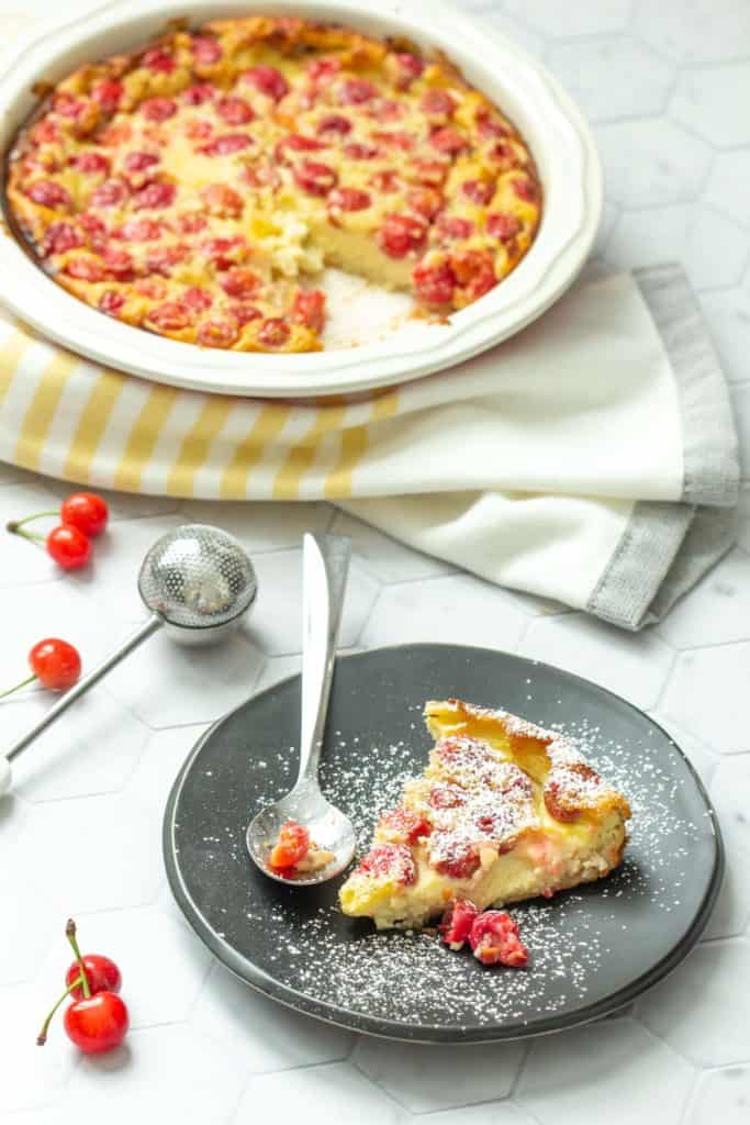 plate of cherry clafoutis with platter behind