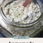 A glass jar filled with homemade ranch seasoning, with a measuring spoon inside, sits on a dark surface. Text reads "homemade ranch seasoning blend.