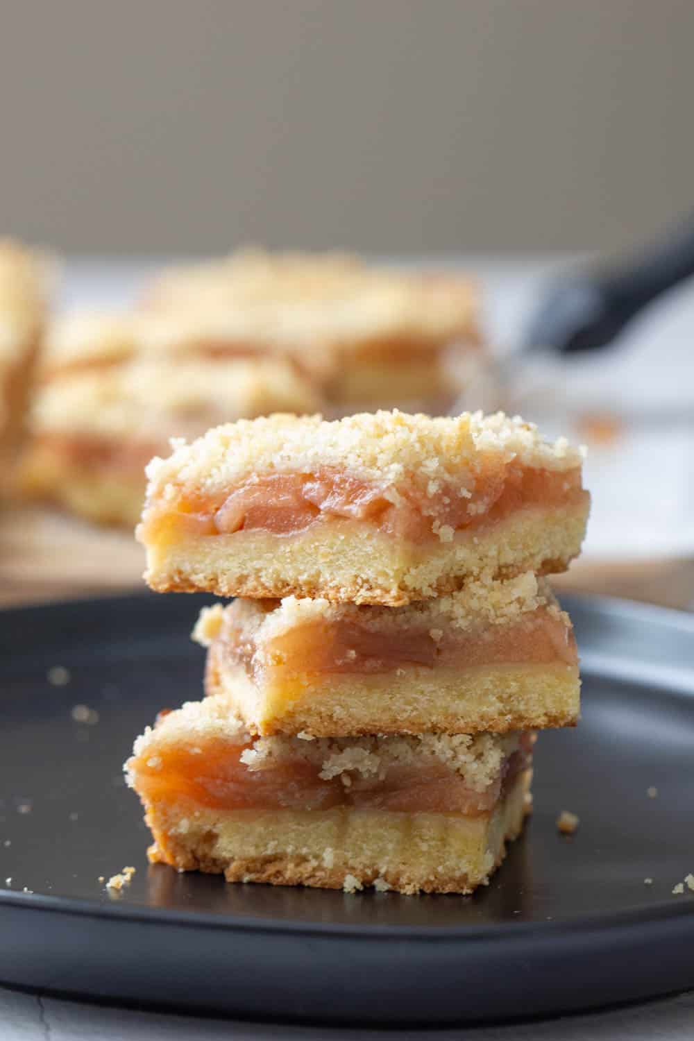 stacked apple pie bars on black plate