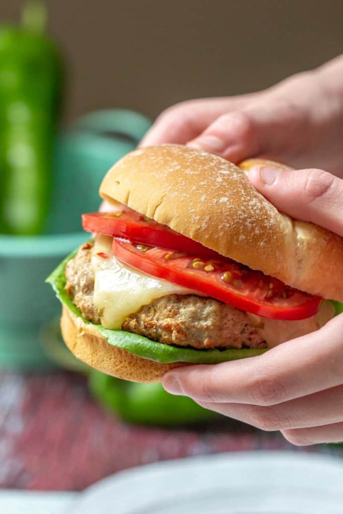 hands holding hatch chile turkey burger