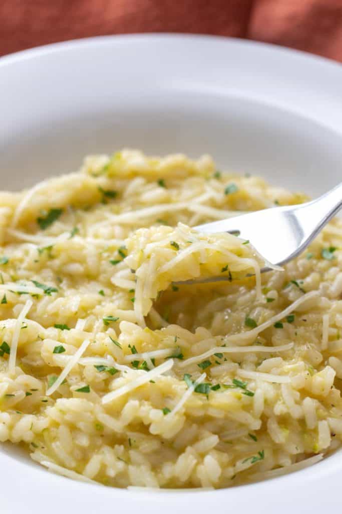 fork scooping up zucchini risotto