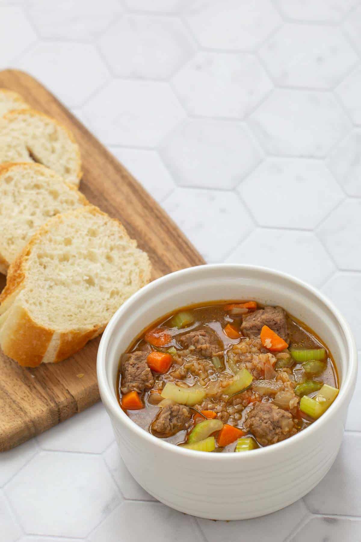 beef bulgur soup in white bowl with bread