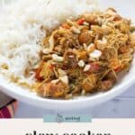 A plate of white rice topped with slow cooker curried chicken, garnished with chopped nuts and herbs. Text reads "slow cooker curried chicken.