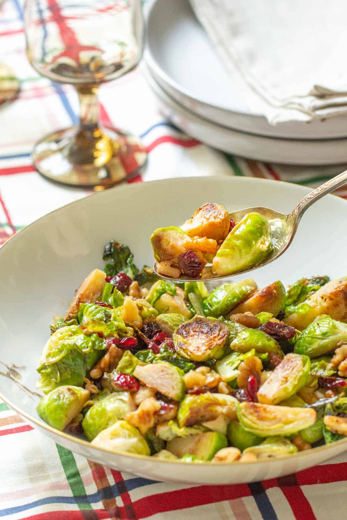 spooning up brussels sprouts with walnuts and cranberries