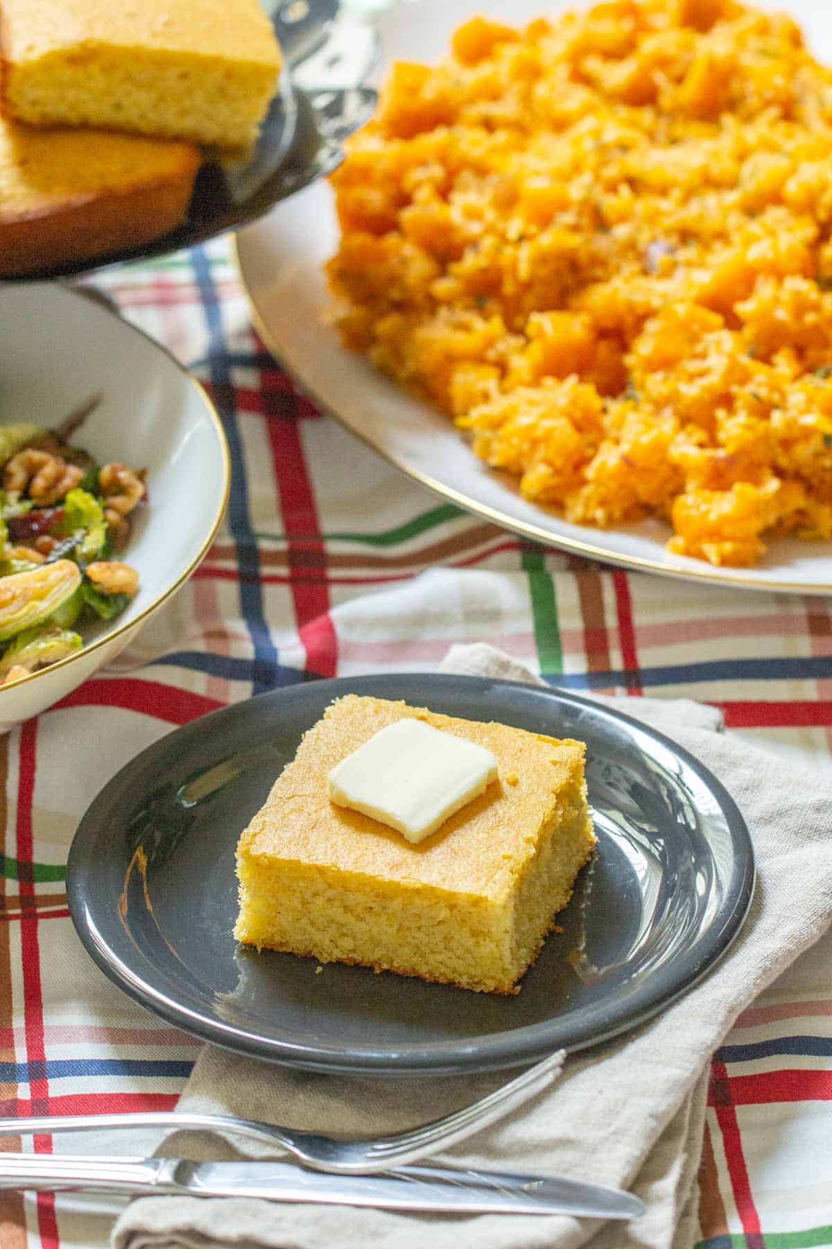slice of buttermilk cornbread with butter on a plate