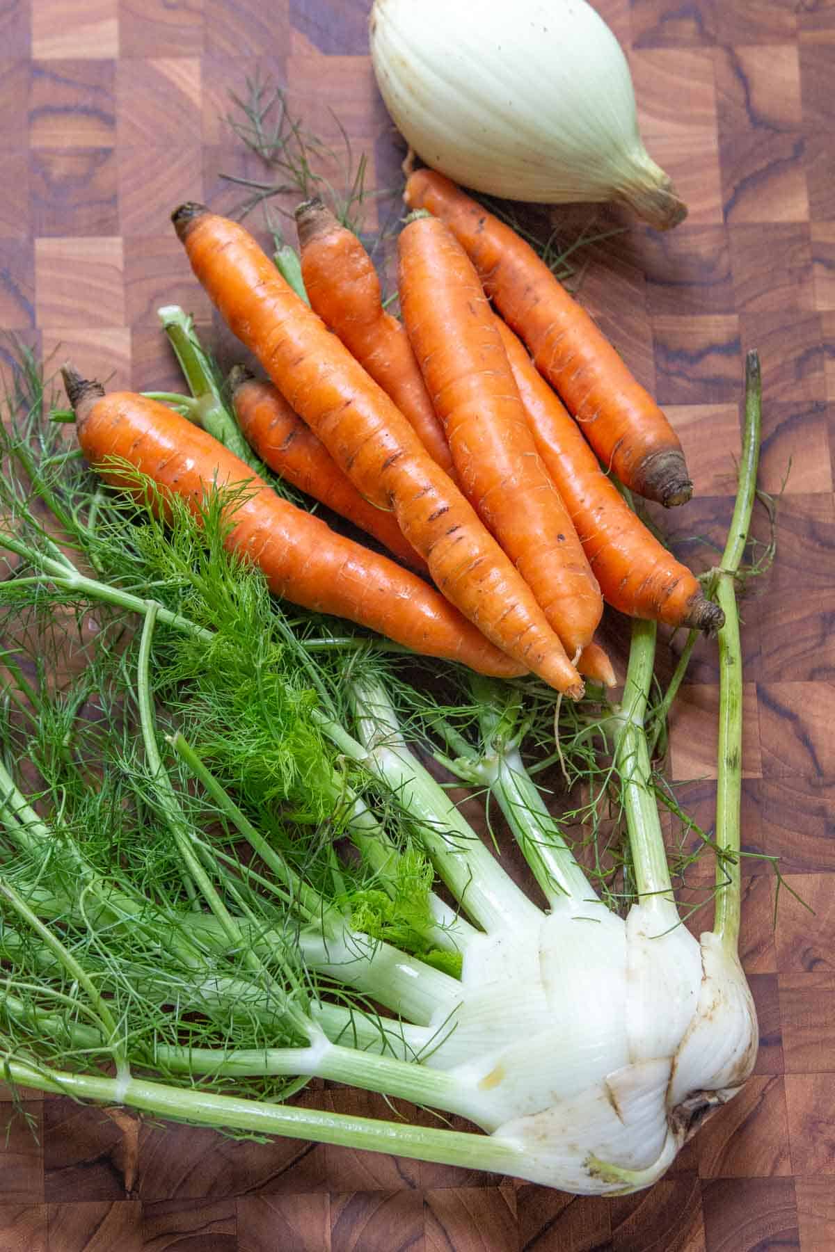 fennel, carrots, and onion on cutting board