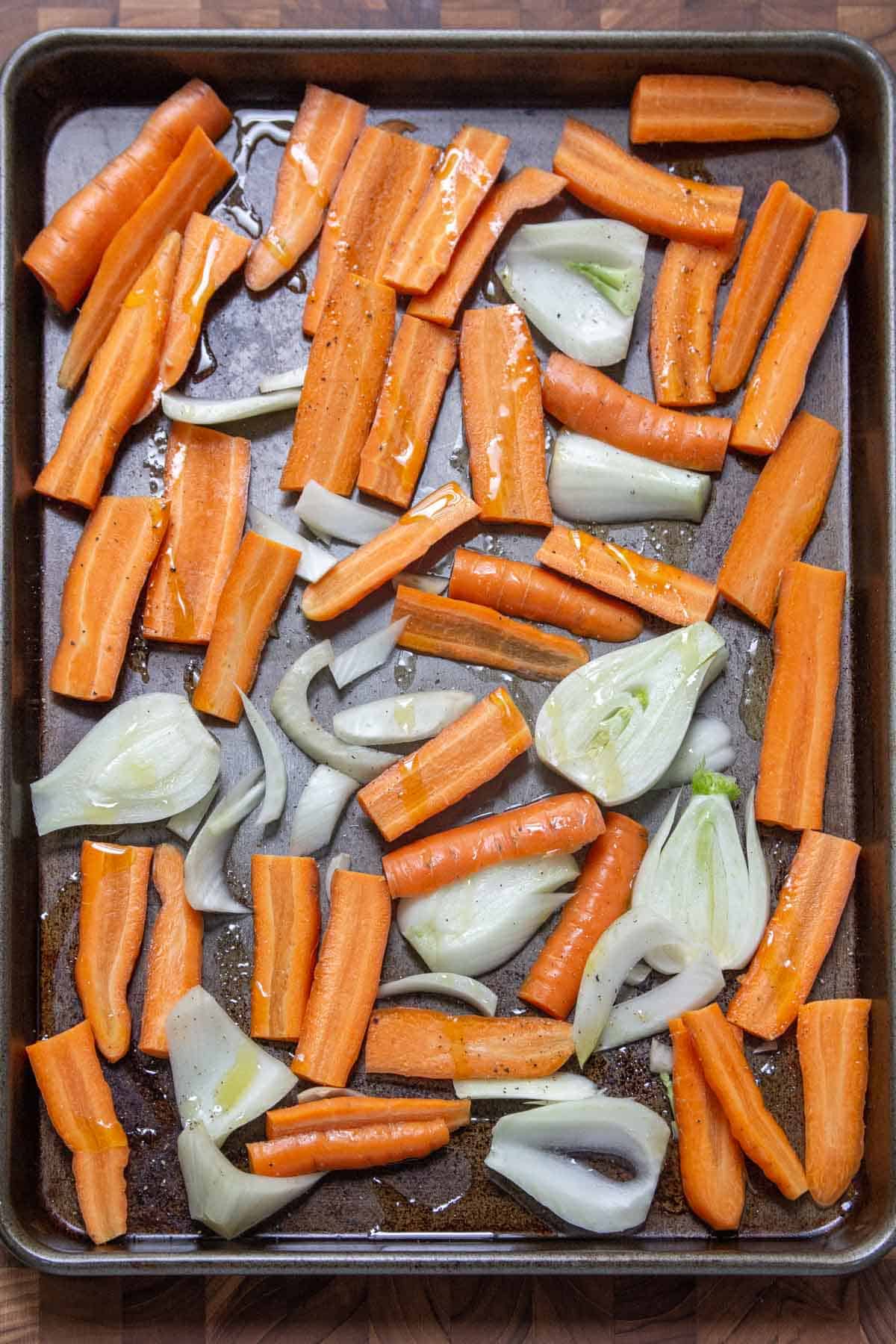 sliced carrots and fennel on cookie sheet