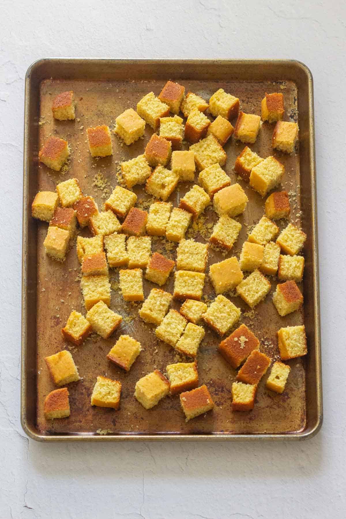 cubes of cornbread on baking sheet