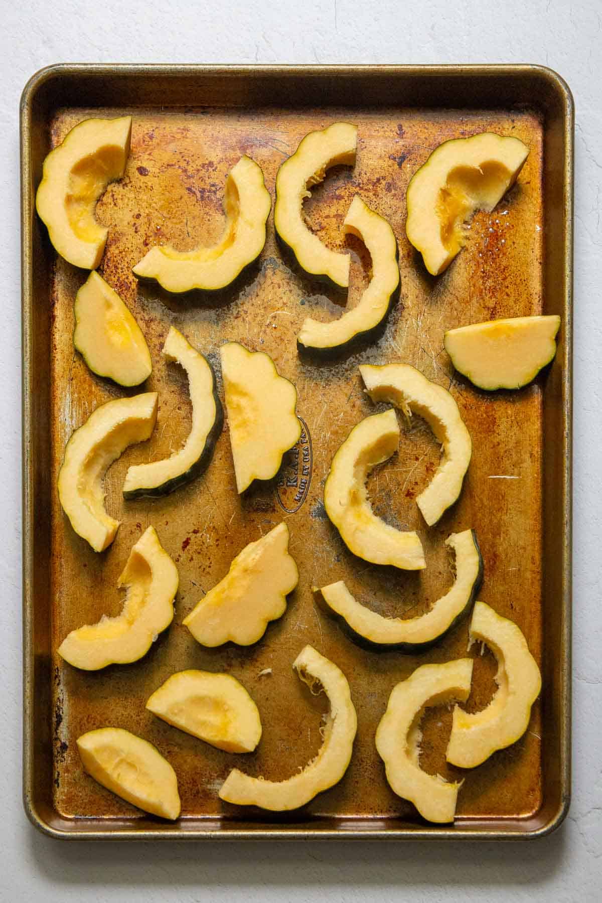 sliced acorn squash on sheet pan