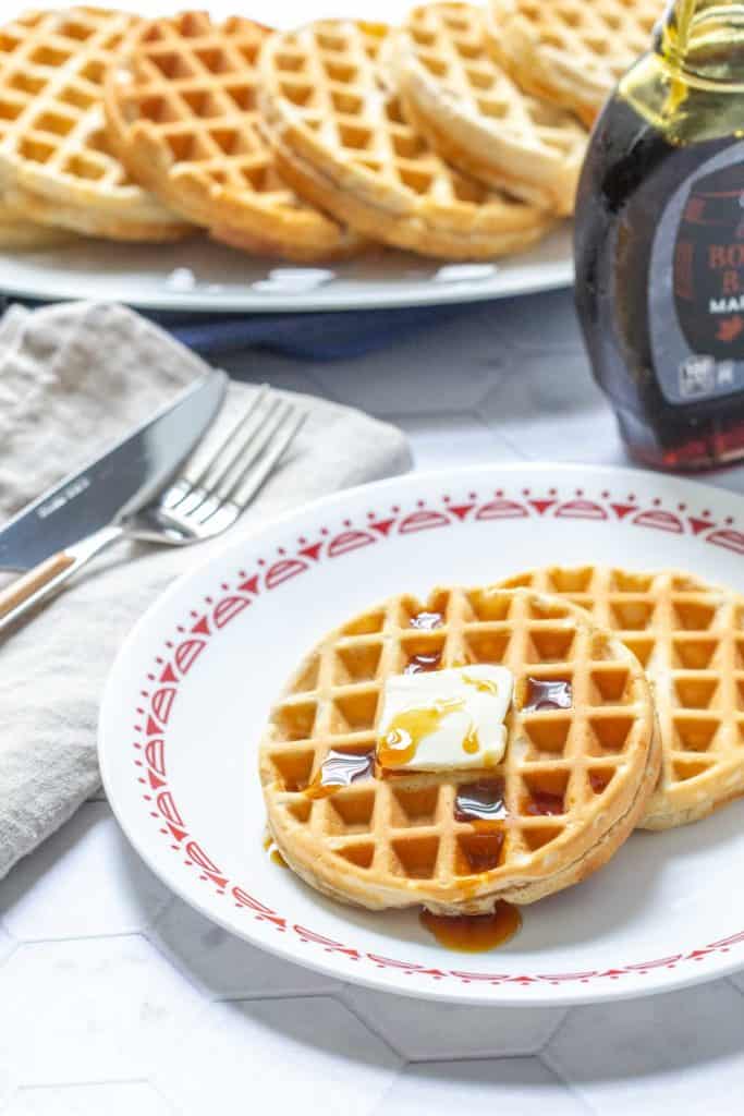 plate of peanut butter waffles with butter and syrup