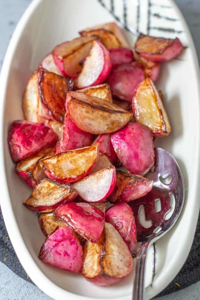 serving bowl of sauteed radishes with serving spoon