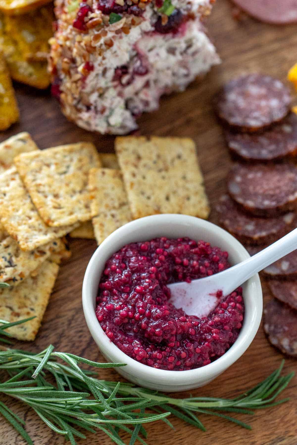 cranberry mustard in bowl with serving spoon on charcuterie board