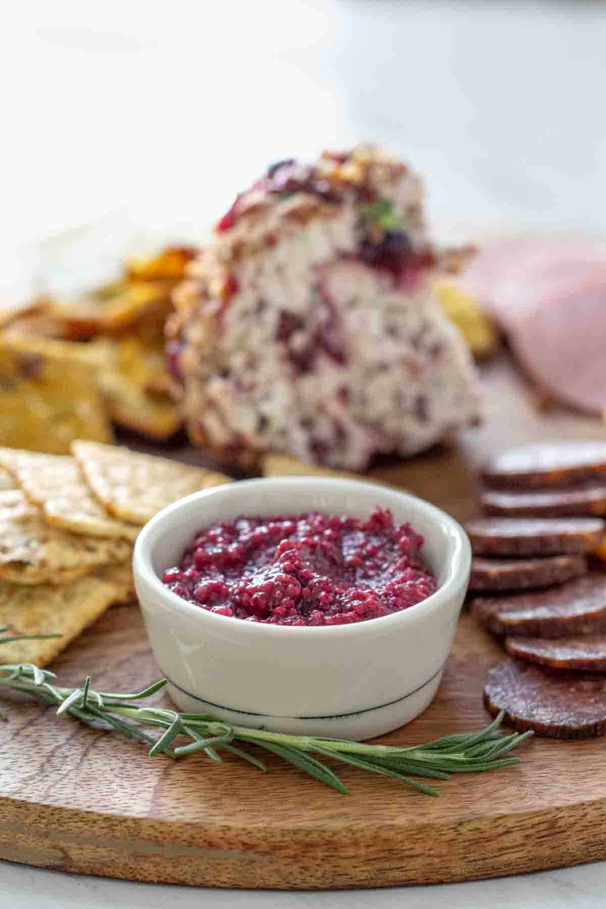 cranberry mustard in white bowl on cheese board