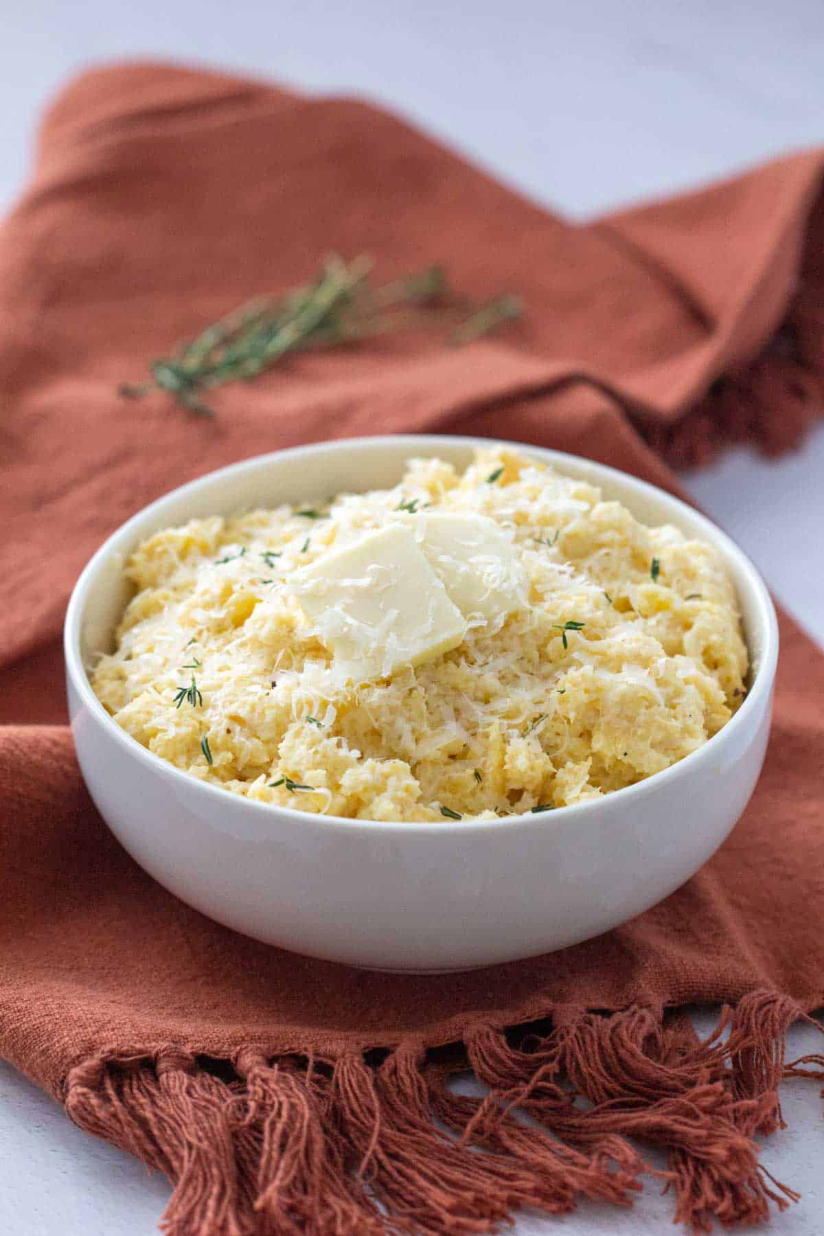 mashed rutabaga in a bowl with butter and cheese