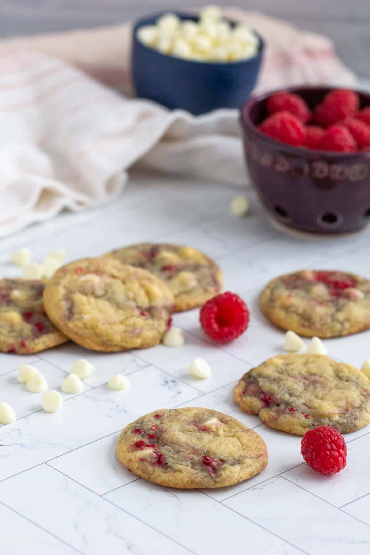 raspberry white chocolate cookies with white chocolate chips and raspberries beside