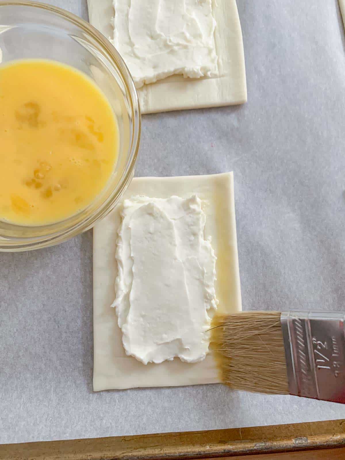 egg being brushed on puff pastry