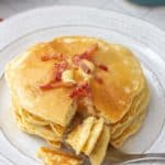 plate of bacon pancakes with fork cutting pieces