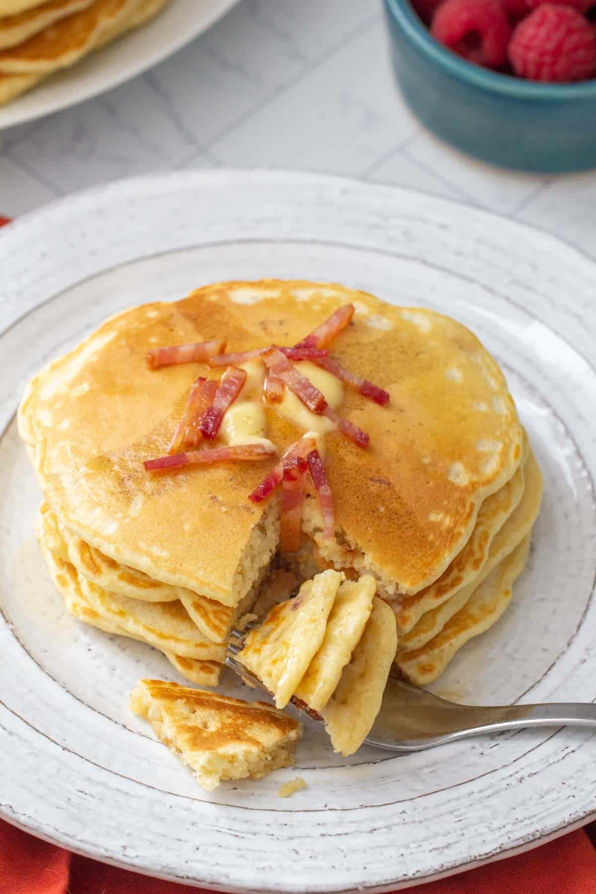 plate of bacon pancakes with fork cutting pieces