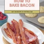 A white dish with cooked bacon strips sits beside a bowl of raspberries and a muffin tin filled with baked goods. A sign displays "How to Bake Bacon—get the recipe and learn how to bake bacon at stetted.com.