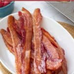 A white dish filled with several strips of cooked bacon sits on a table; text above reads "how to bake bacon," making it easy to learn the perfect way to prepare this tasty breakfast favorite.