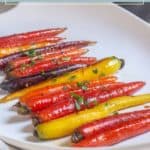 A plate of maple glazed carrots, beautifully roasted rainbow varieties, is finished with a touch of chopped parsley for a vibrant and flavorful side dish.