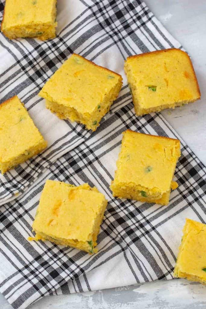 squares of jalapeno cornbread on a black and white plaid napkin