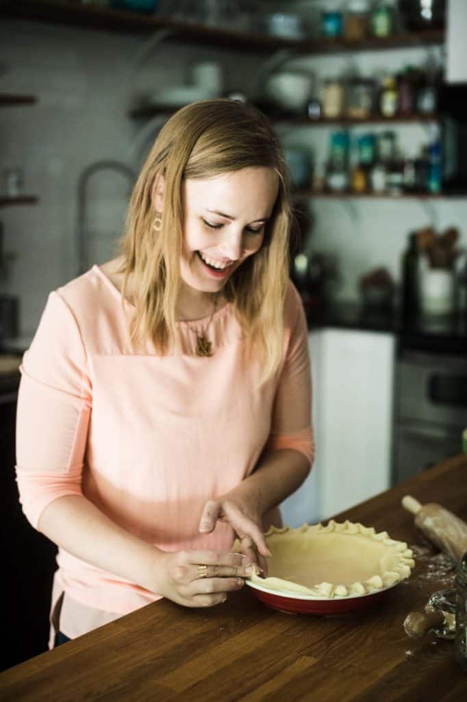 blond woman shaping pie crust