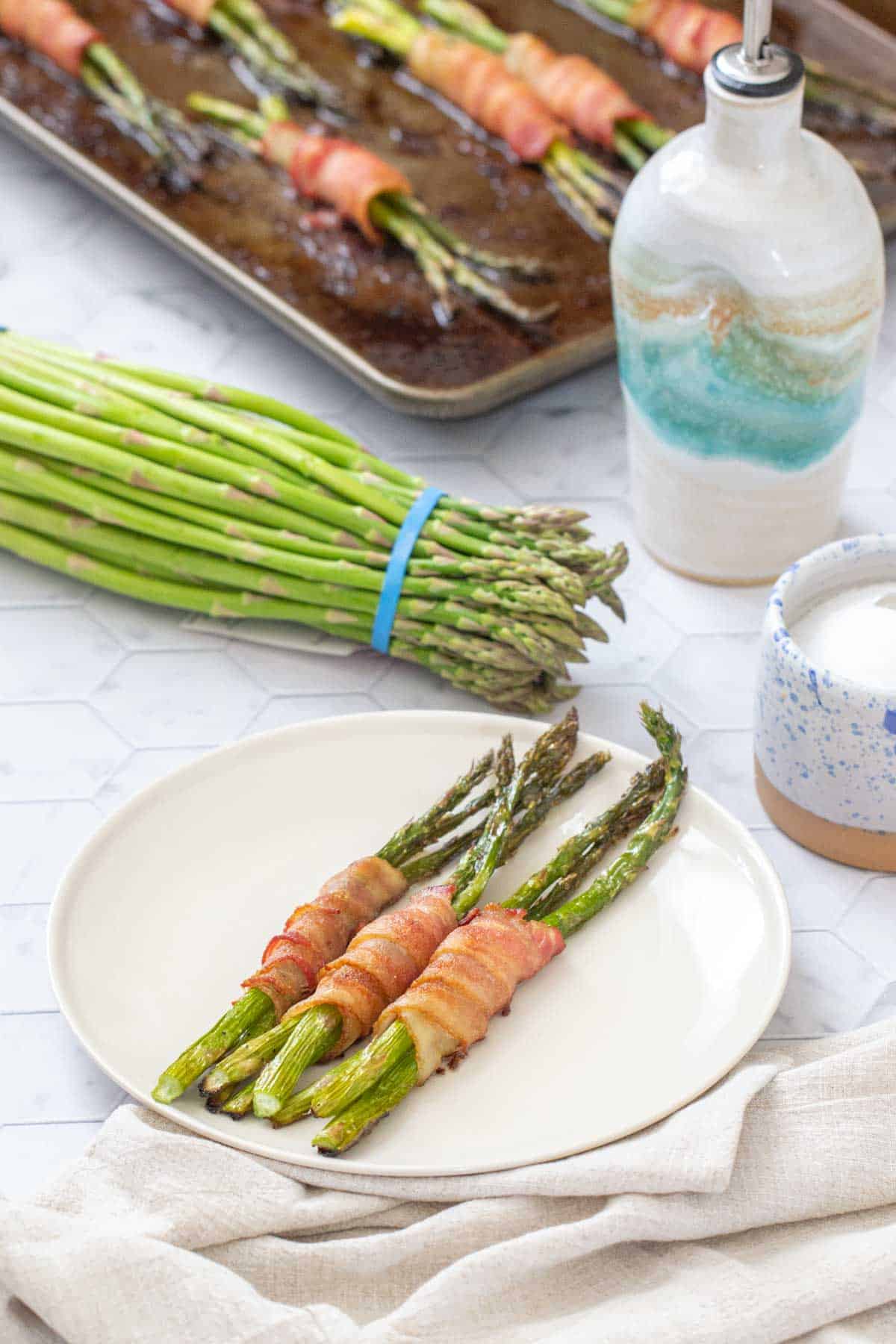 bacon wrapped asparagus with asparagus bundle behind