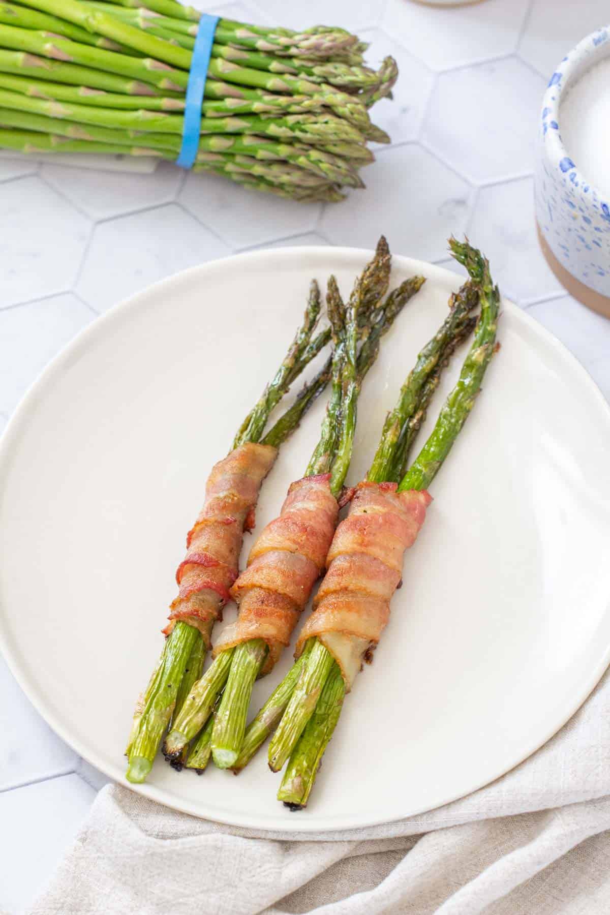 overhead bacon wrapped asparagus on white plate