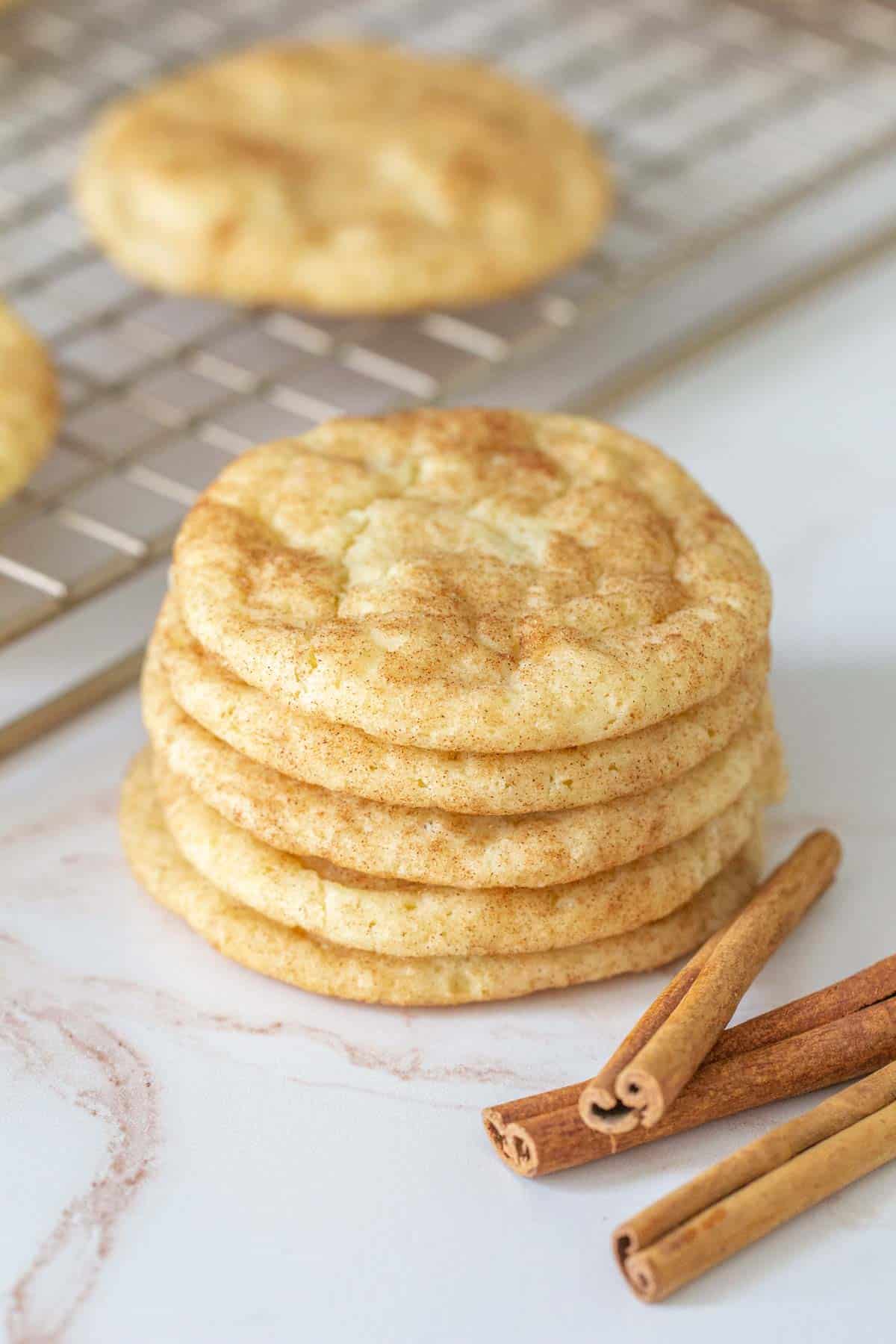 stack of snickerdoodle cookies with cinnamon sticks