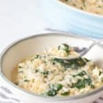 spinach risotto in bowl with spoon