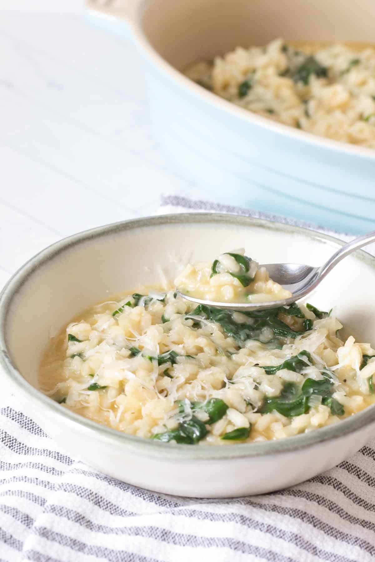 spinach risotto in bowl with spoon