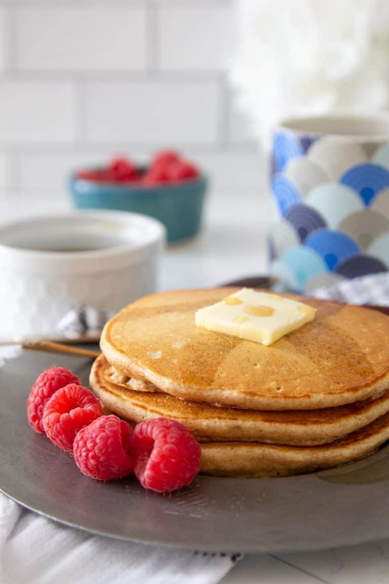 whole wheat pancakes on plate with raspberries