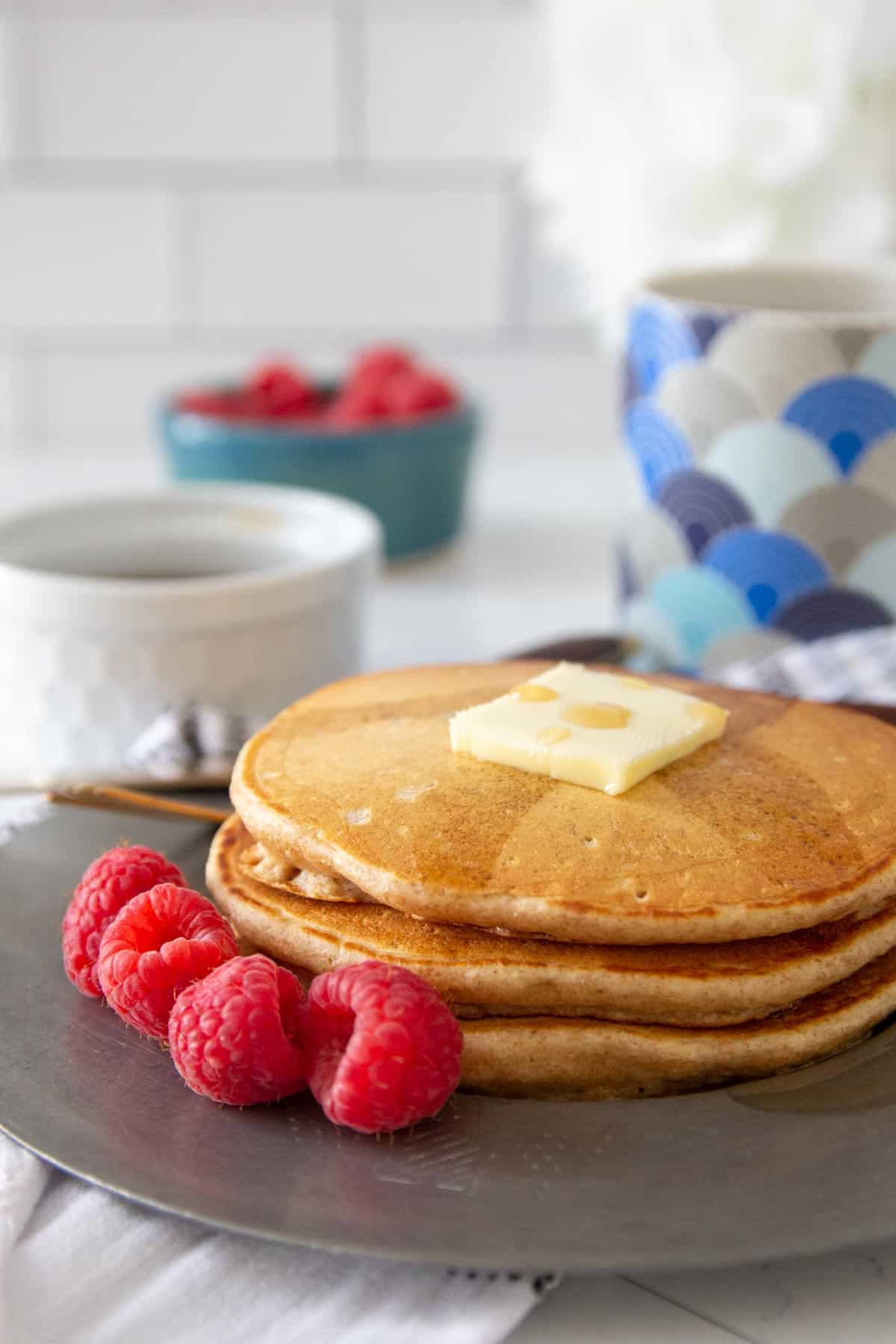 whole wheat pancakes on plate with raspberries