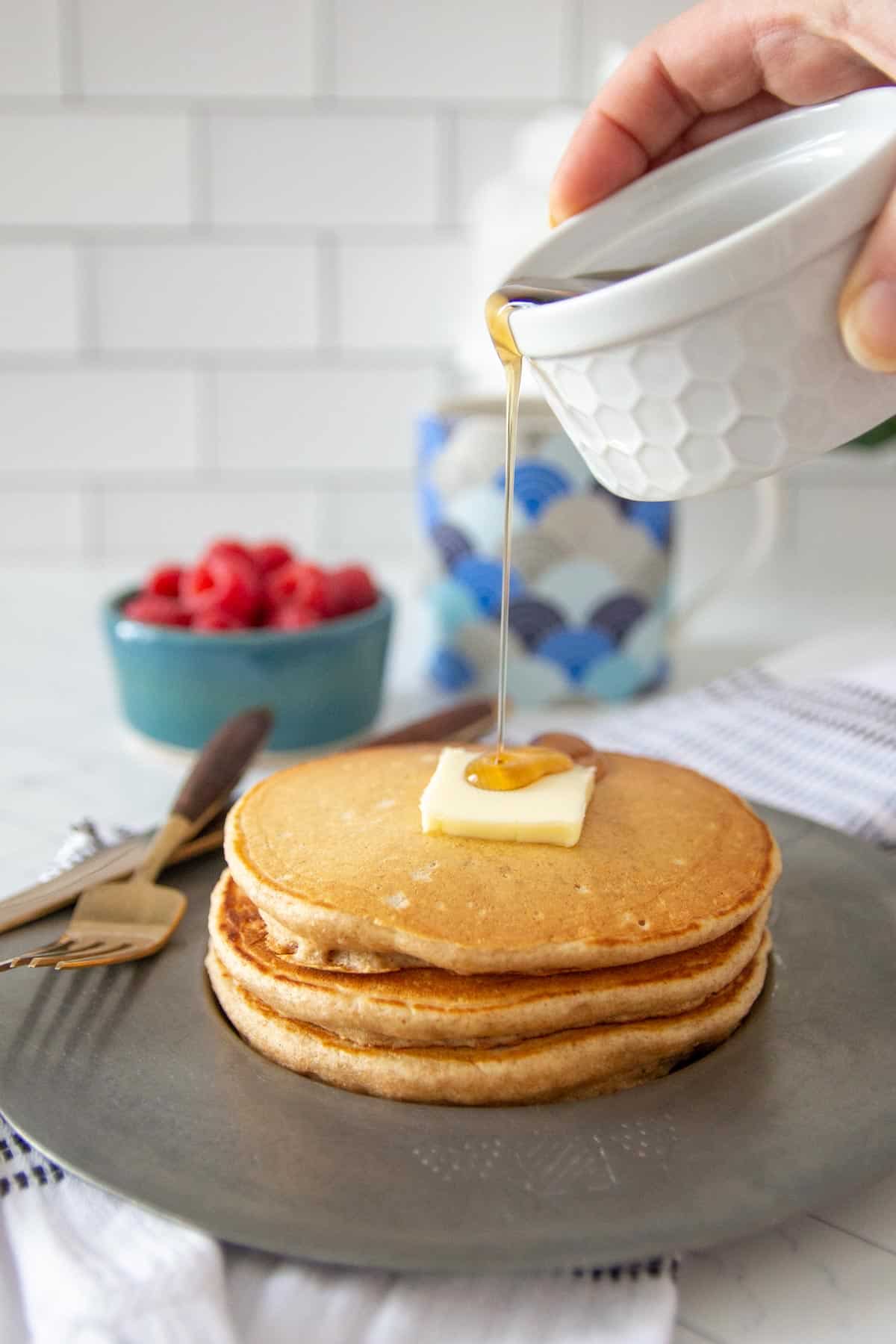 syrup pouring onto whole wheat pancakes
