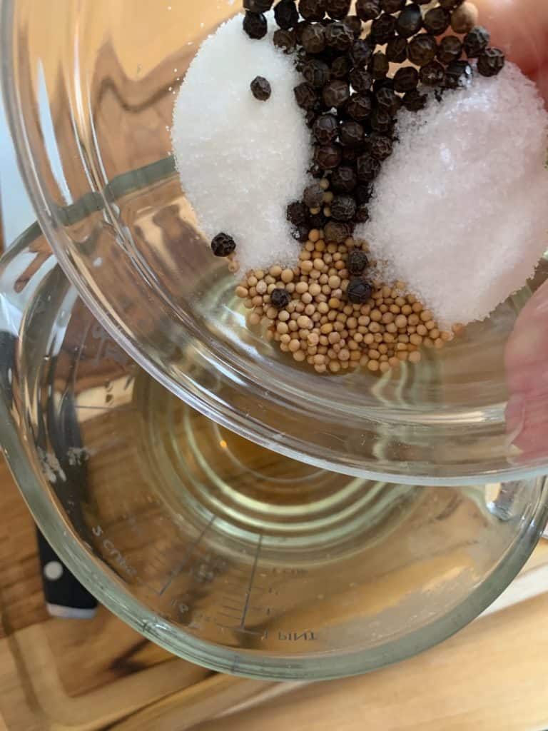 adding spices to pickle brine