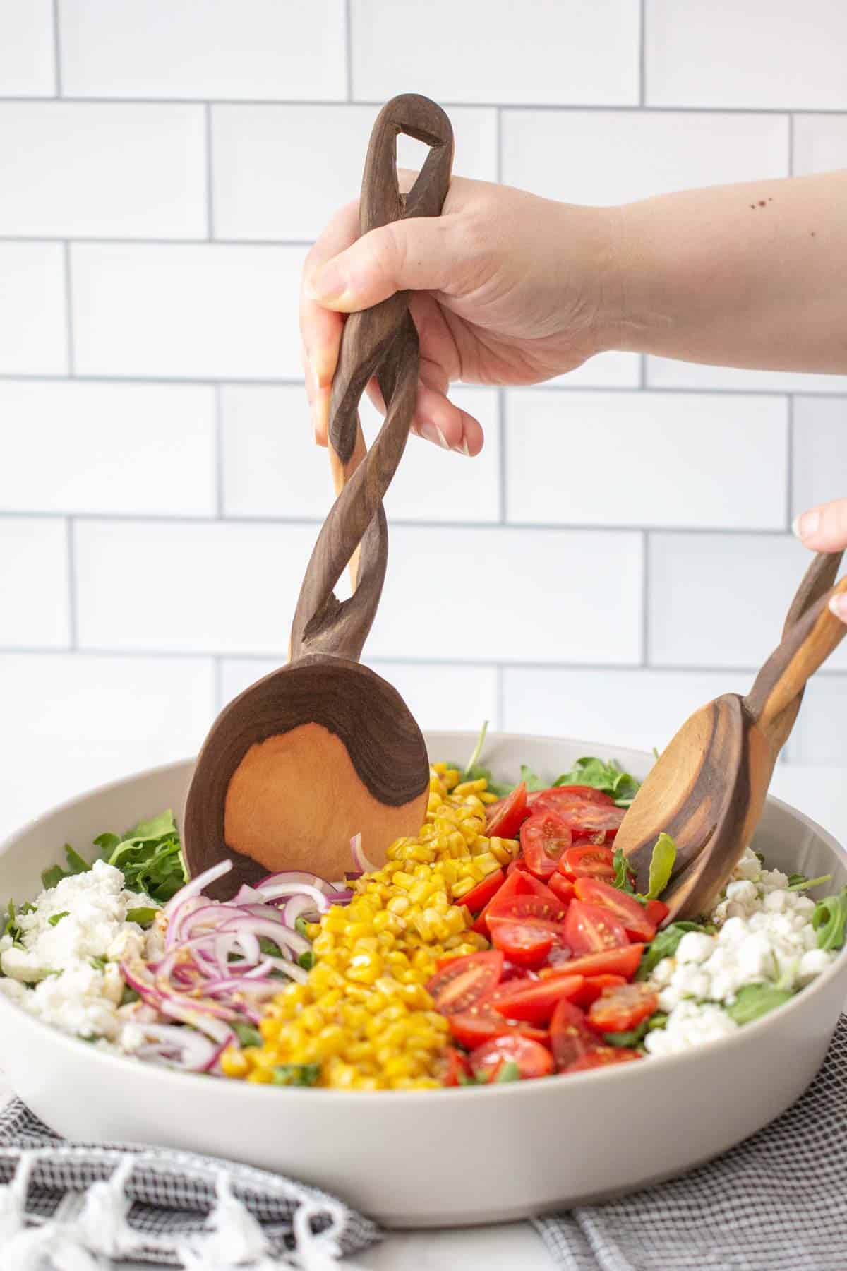 tossing roasted corn salad