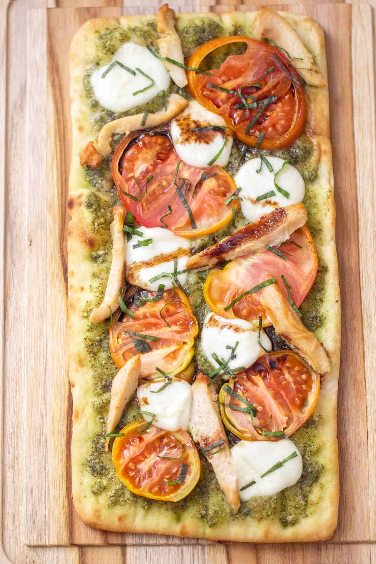 overhead caprese flatbread with chicken on cutting board