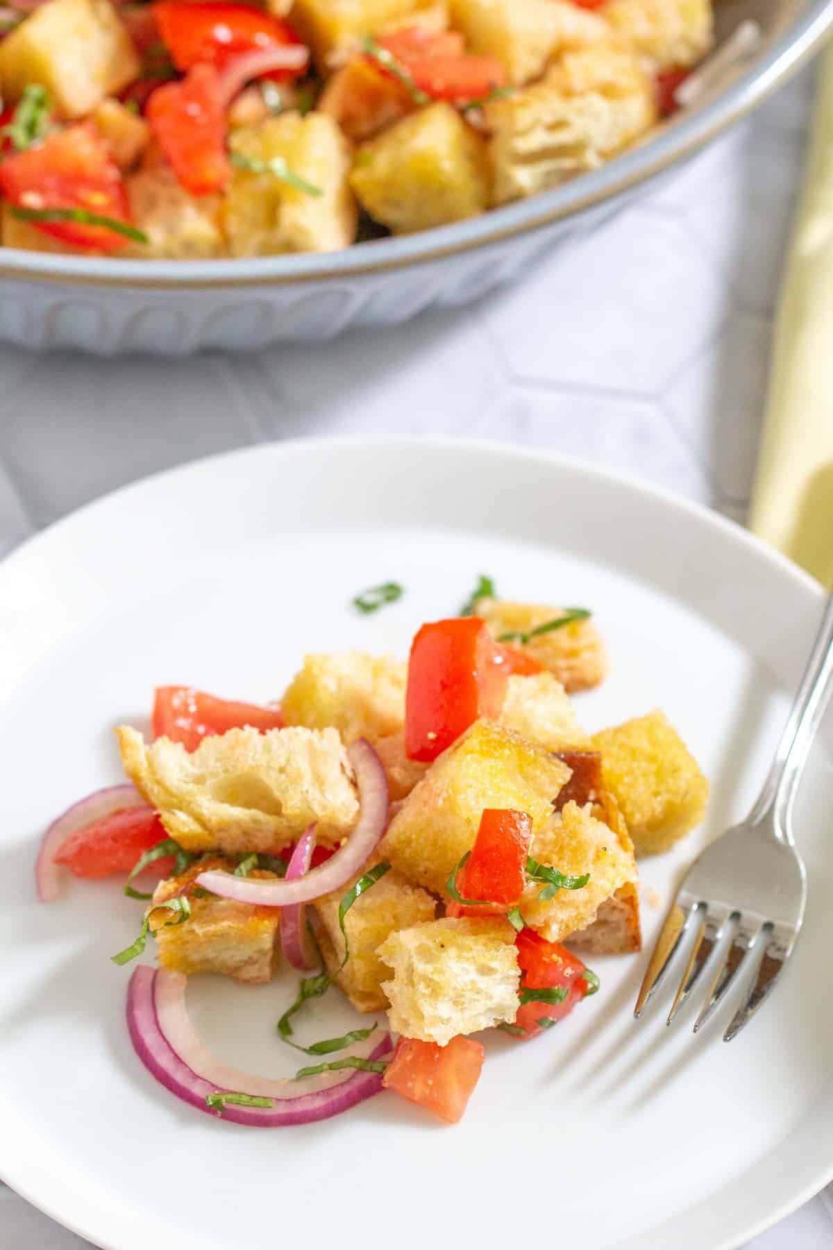 panzanella on a white plate with a fork