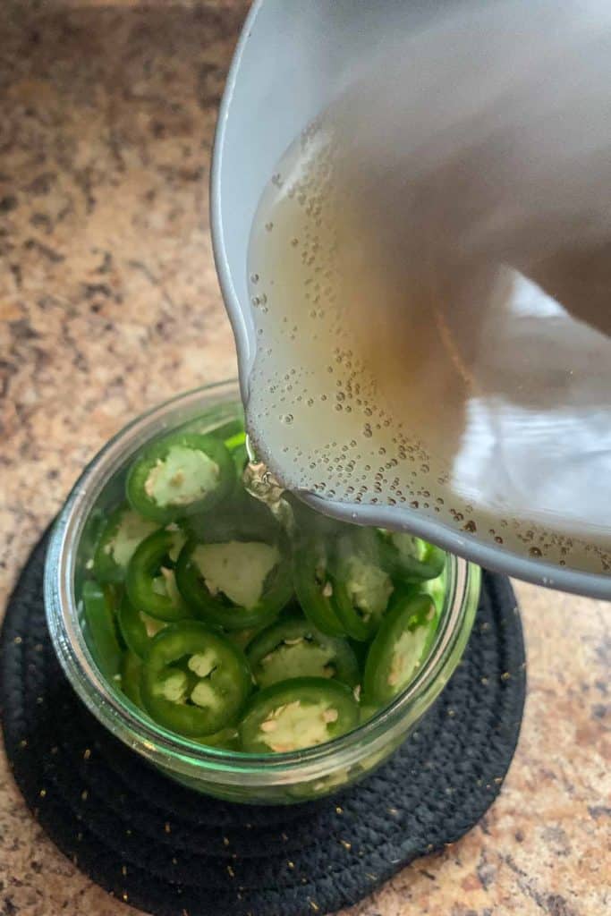 pouring brine over jalapenos