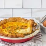 slice of cheese quiche being lifted from pie plate