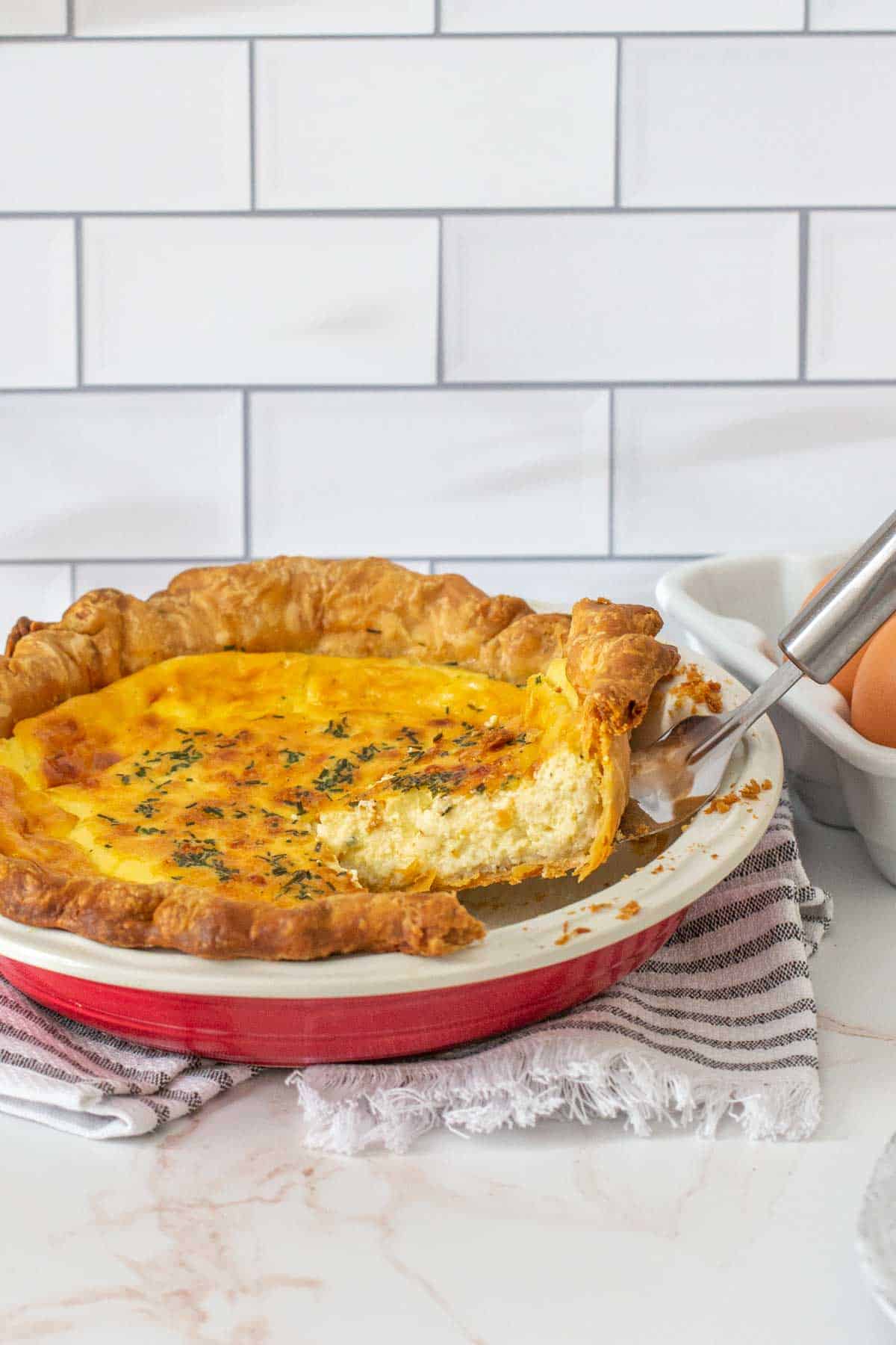 slice of cheese quiche being lifted from pie plate