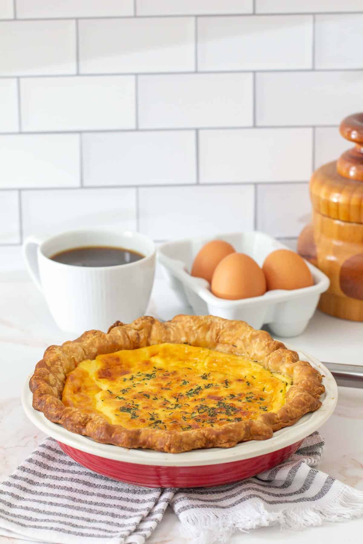 baked cheese quiche in red pie plate