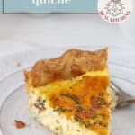 A slice of cheese quiche with herbs sits on a white plate, showcasing the classic savory flavors of cheese quiche, with eggs and a cup in the blurred background.