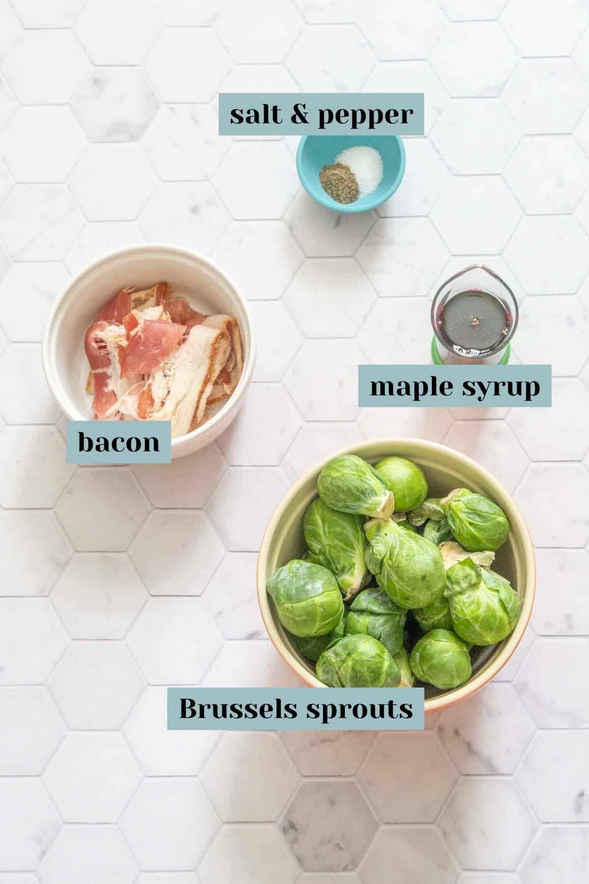 ingredients for maple bacon brussels sprouts on tile surface with labels