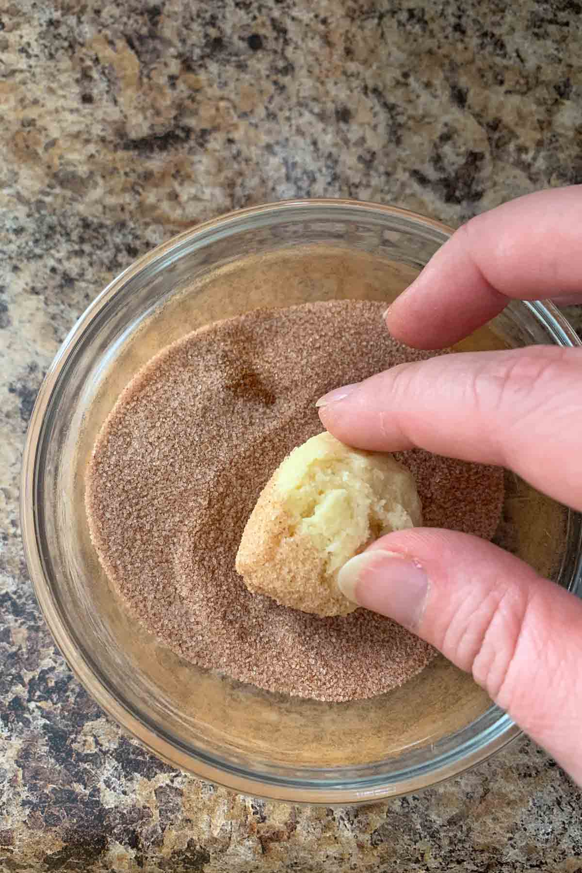 coating snickerdoodle cookie dough balls in cinnamon sugar