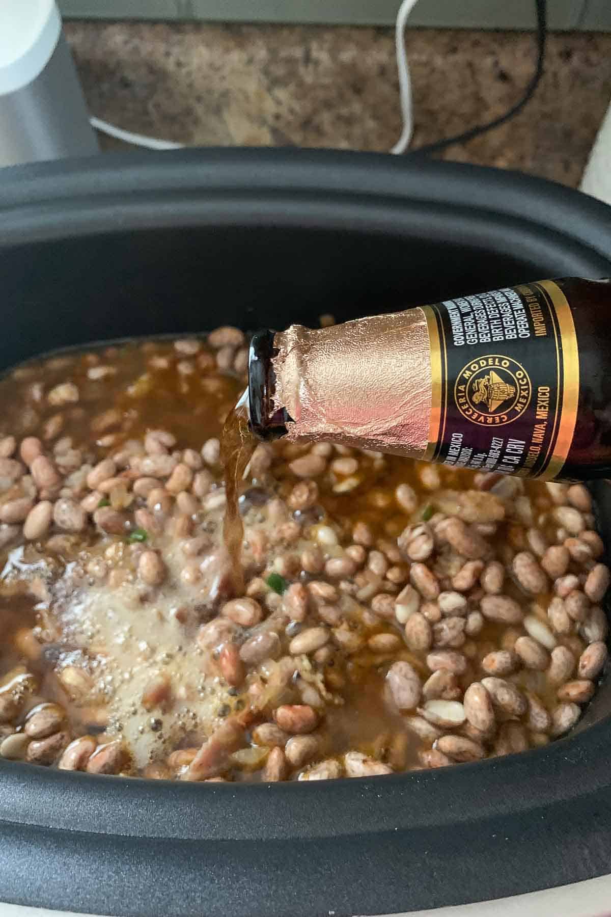 adding beer to borracho beans