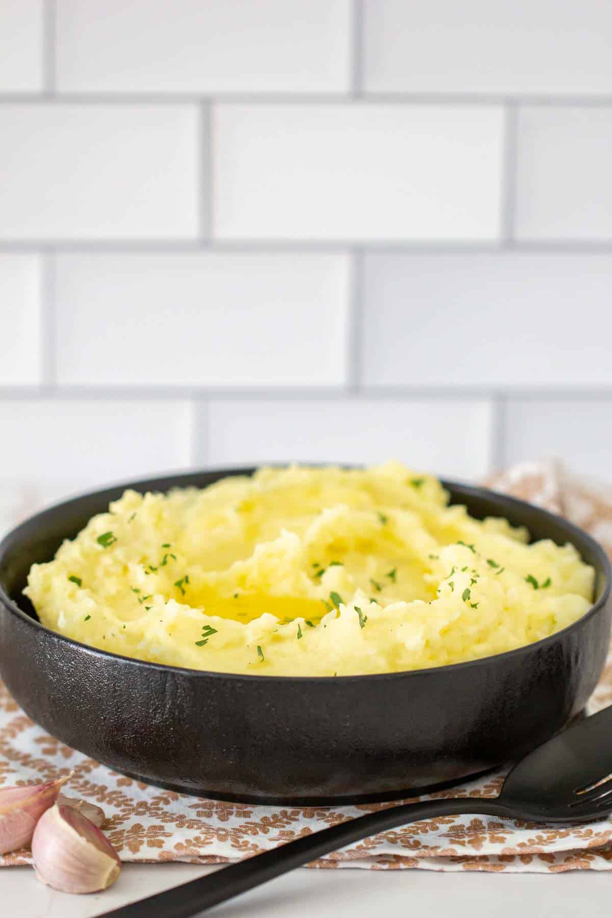 black bowl of garlic mashed potatoes