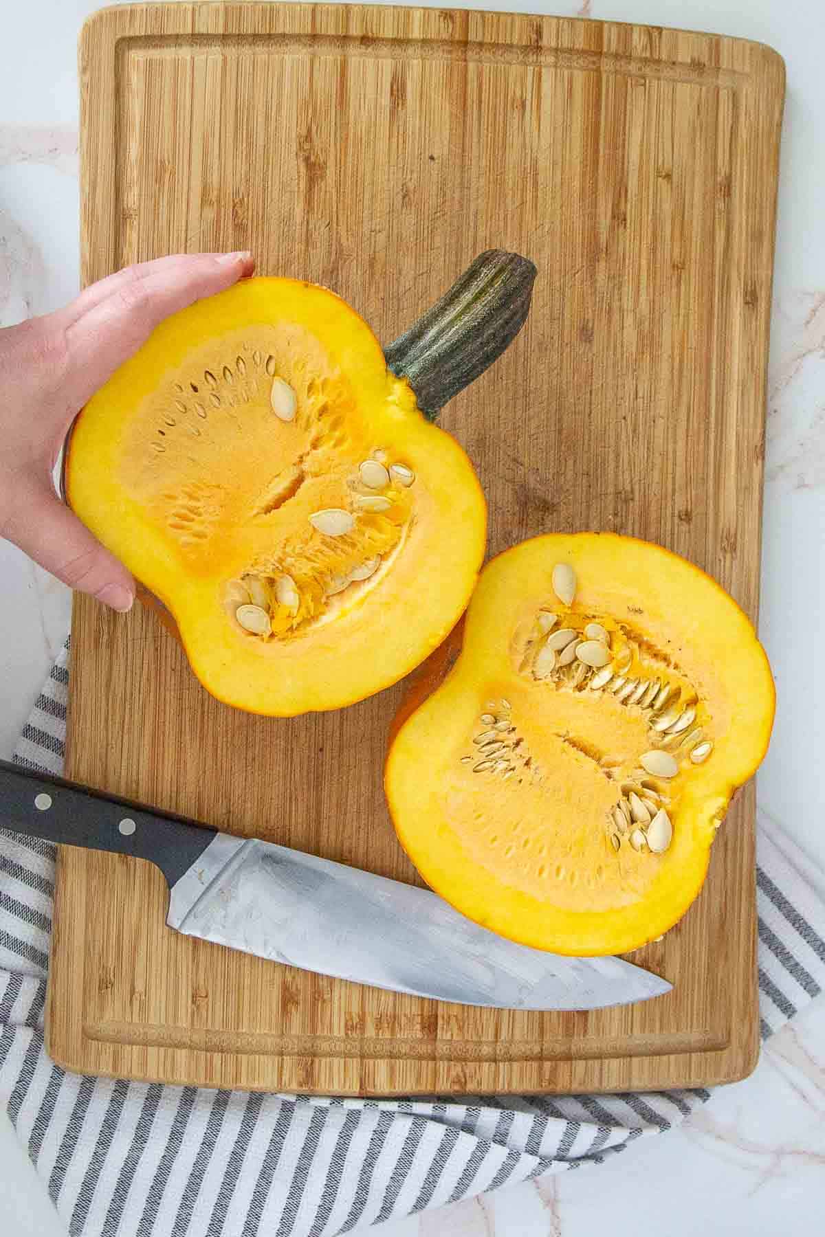 halved pie pumpkin on cutting board